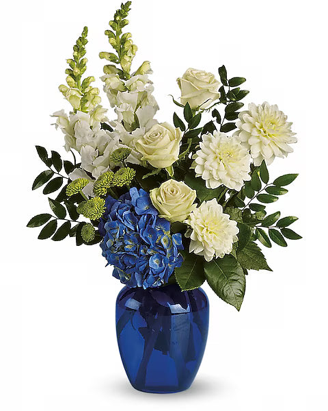 Floral arrangement with white and yellow flowers and blue hydrangeas