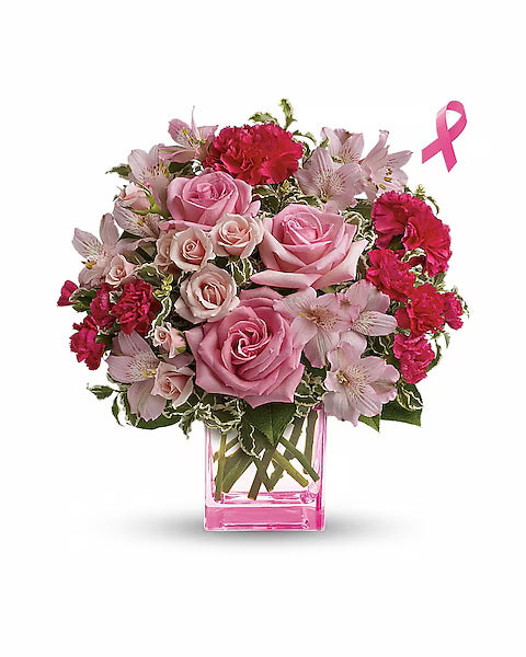 Vibrant pink and red flower bouquet in a clear pink vase