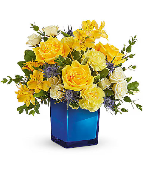 Bouquet of yellow roses and yellow carnations in a blue vase on a white background