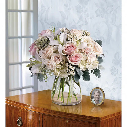Fresh flower arrangement in vase on wooden table