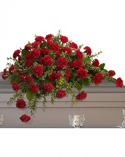 Red flowers with green leaves on a gray casket with a white background