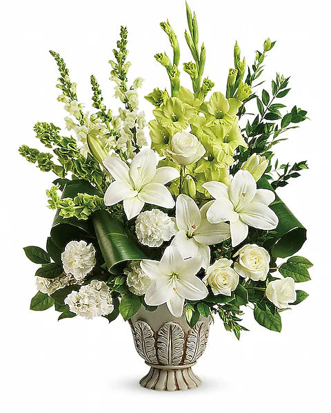 Decorative white and green floral arrangement with white and green flowers in vase on white background