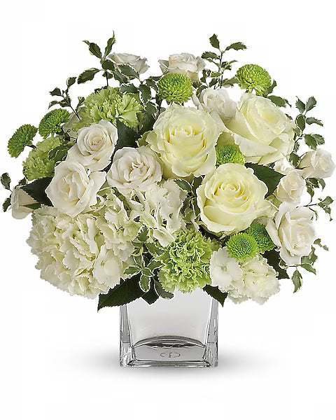 Fresh white and green flowers arranged in a clear vase.