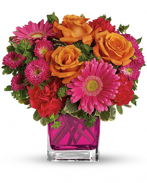 Colorful flower arrangement with pink, orange, and red flowers in a pink vase on a white background